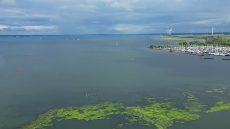 hermoso dron aéreo disparado sobre stellendam, puerto, barcos atracados, pantano, pantano y estuario con molinos de viento en el paisaje