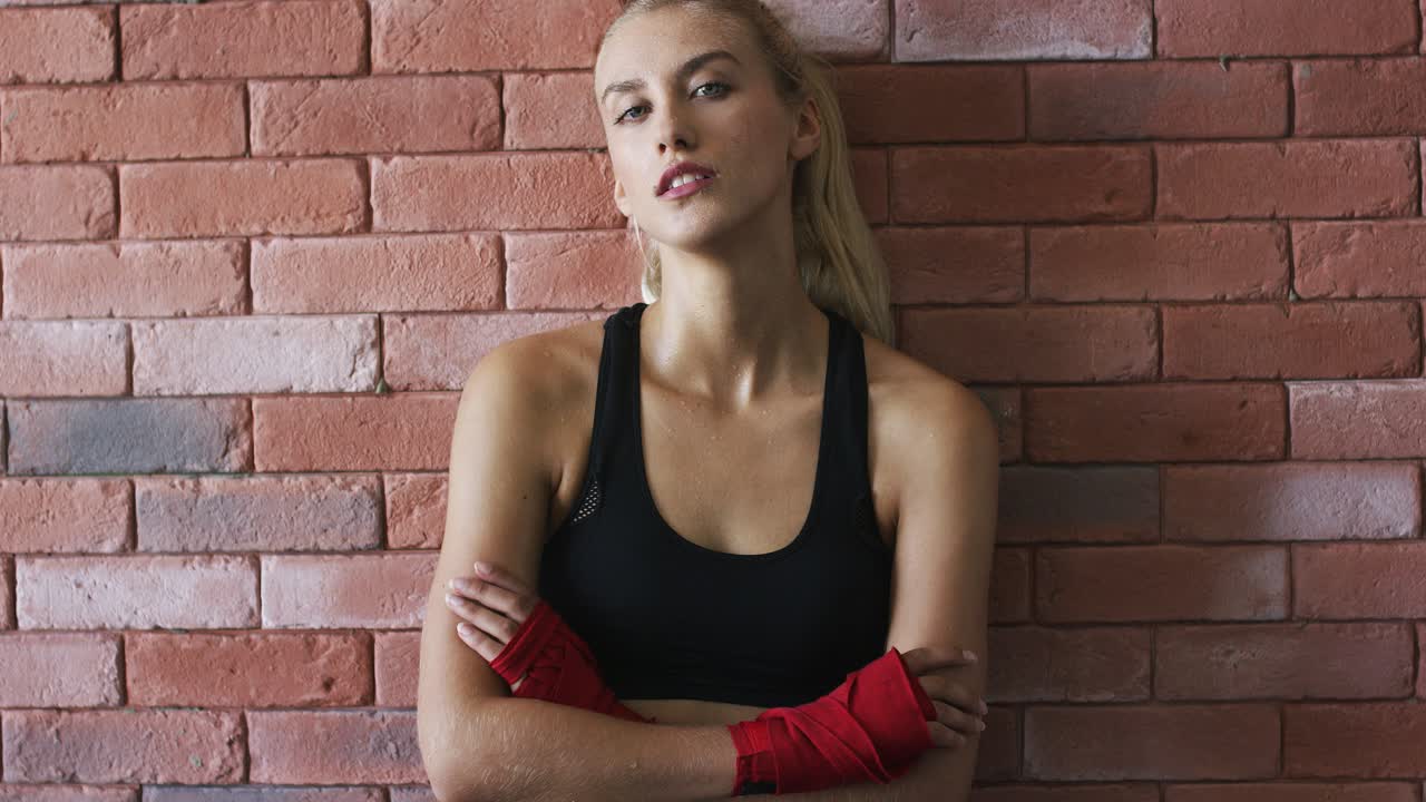 deportista positiva apoyada en la pared de ladrillo