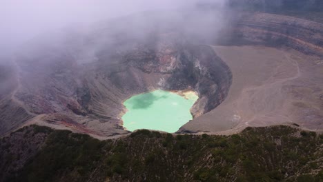 aérea: se forma una nube sobre el lago del cráter verde y caliente del volcán santa ana