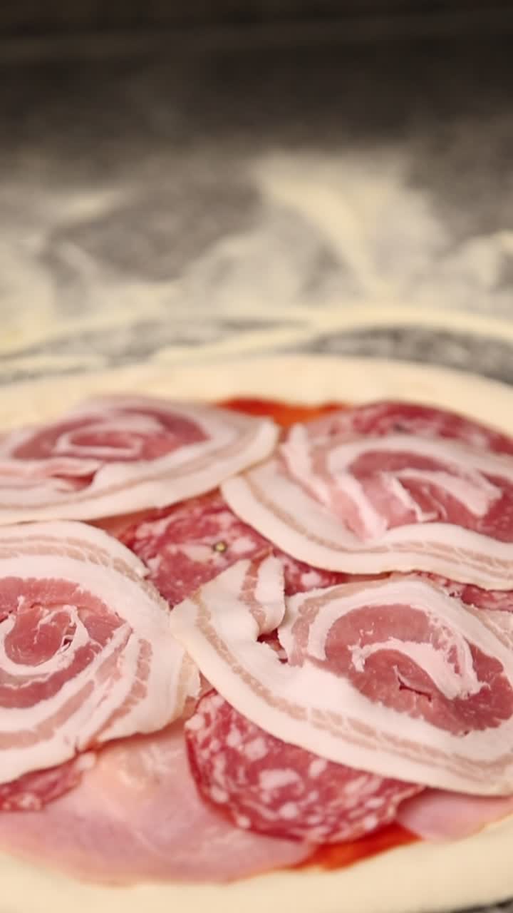 Pizza cruda con prosciutto, salame e pancetta pronta da cuocere