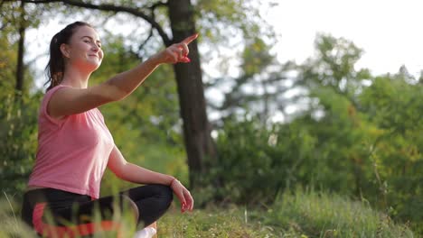 portrait of young girl sitting on sports mat and making yoga meditation in lotus pose with group portrait of young girl sitting on sports mat and making yoga meditation in lotus pose with group together at big fitness club