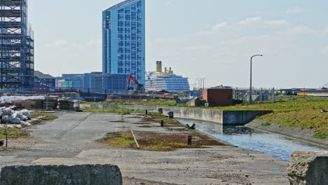 Barco-Crucero-Atracado-En-El-Puerto-A-Distancia-Mientras-Se-Está-Construyendo-Y-Regenerando-Los-Muelles