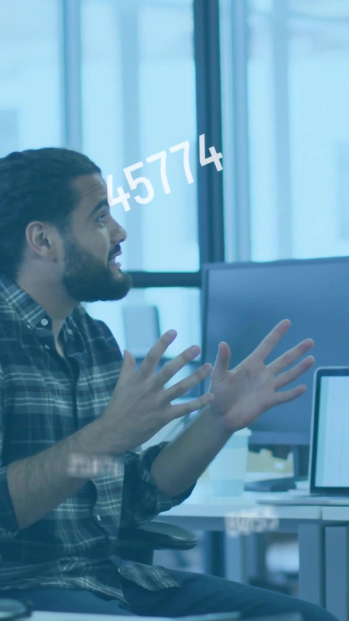Vertical video: Man gesturing on offscreen cue, showing tech data, numeric HUD moving over screen