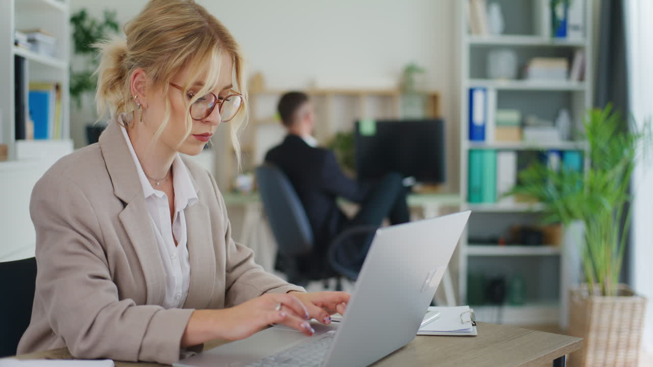 Kvinne skriver på laptop på kontor