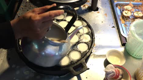 concepto de cocina. tipo de carne dulce tailandesa. leche de coco mezclada con postre frito en polvo en el mercado de comida callejera tailandés de la noche. postre de carne tradicional tailandesa, panqueque, pudín. imágenes de 4k.