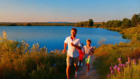 father and son running by a lake at sunset