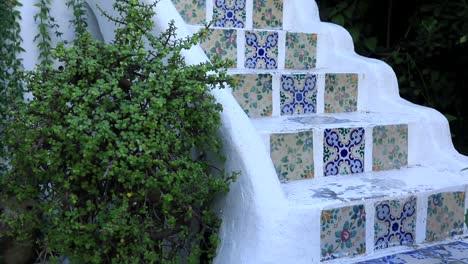 whitewashed wall with vibrant blue patterned tiles on steps, sidi bou said style, close-up