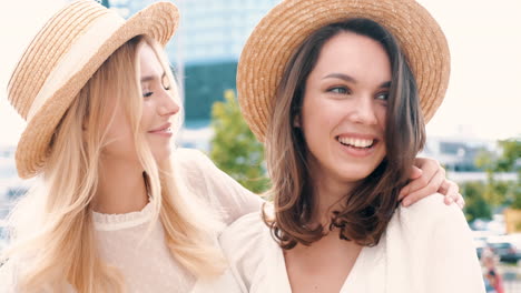 two women laughing in straw hats