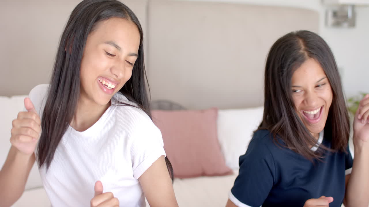 Teenage girls dancing and laughing, enjoying time together at home