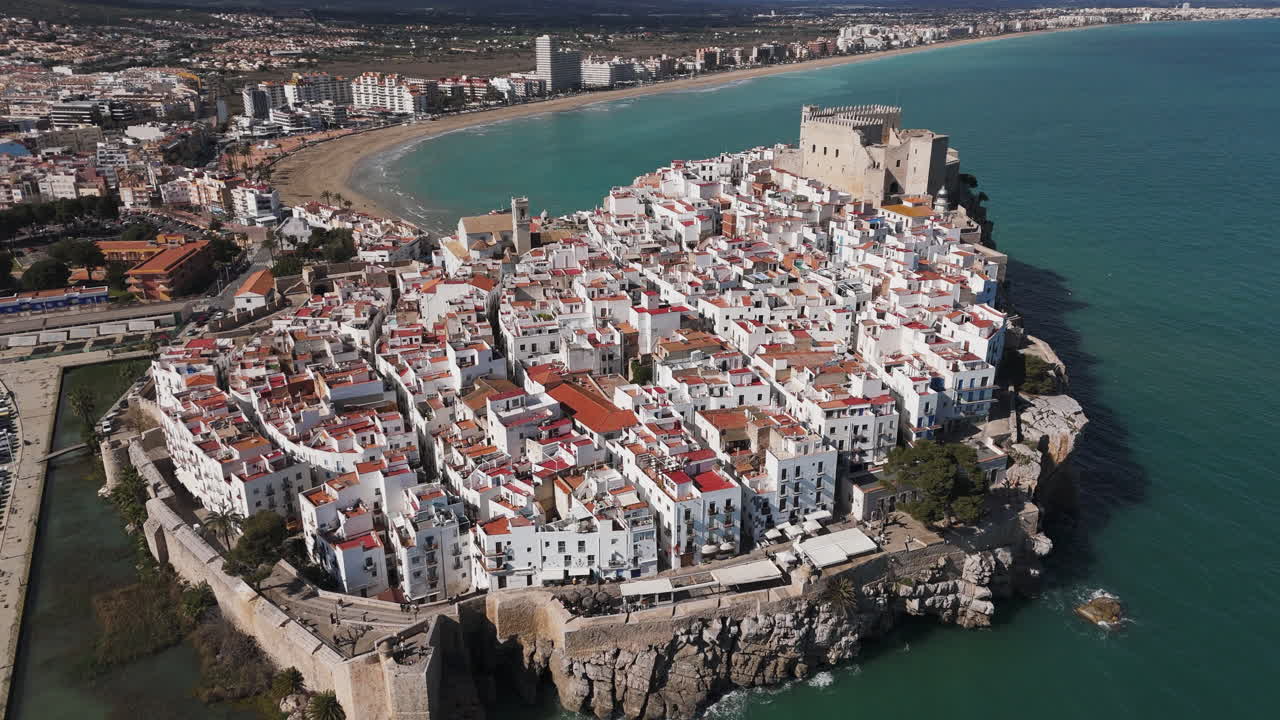 Aerial tracking over Castell de Peniscola with city walls and Mediterranean water surround