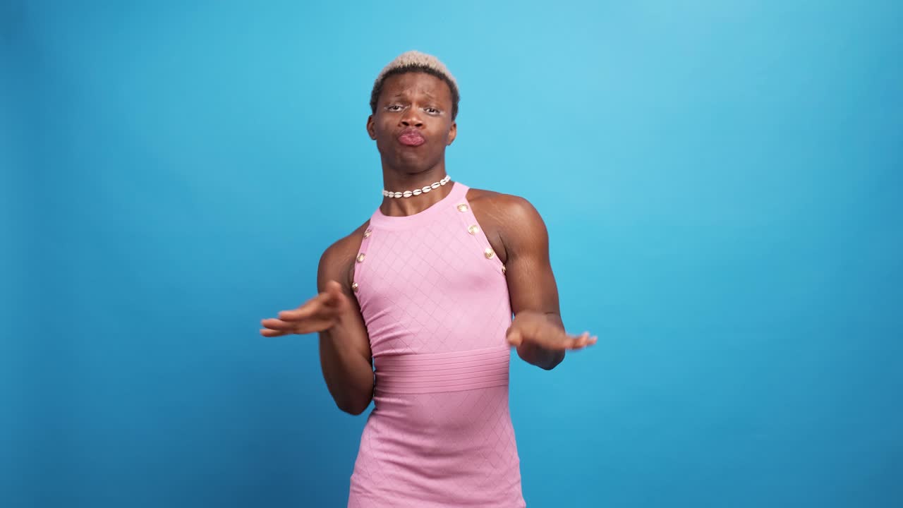 Black androgynous model in pink dress dancing