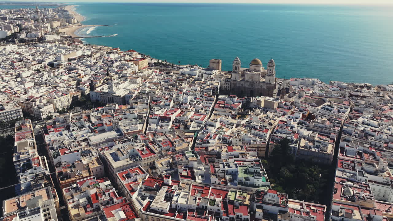 Smuk og bred drone panoramaudsigt over Cádiz i Spanien, Andalusien, Europa på en lys og solrig dag med udsigt til Cádiz katedralen og havnefronten. Langsom filmisk skyline etablerer panoramaudsigten.