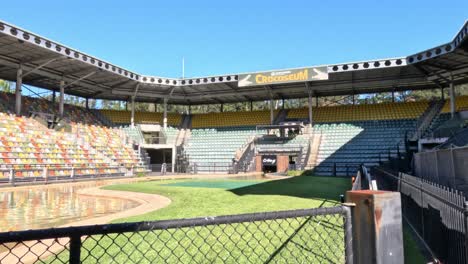 estadio vacío con asientos coloridos y arena central