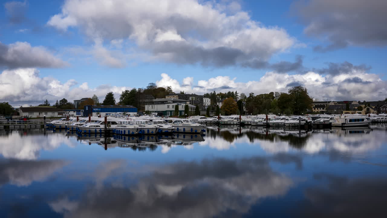timelapse de carrick en la ciudad de shannon en el condado de leitrim y roscommon con tráfico de botes, personas y nubes en movimiento en el río shannon en irlanda