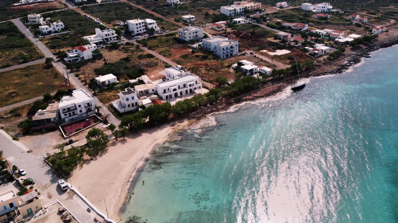 Aerial drone moving towards the coastal village of Diakofti and its turquoise sandy beach. Kythira, Greece