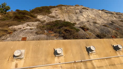 Devils-Slide-retaining-wall-along-the-closed-stretch-of-Route-1-in-Northern-California-near-Half-Moon-Bay,-Pacifica-Beach,-and-San-Francisco---4K-60fps