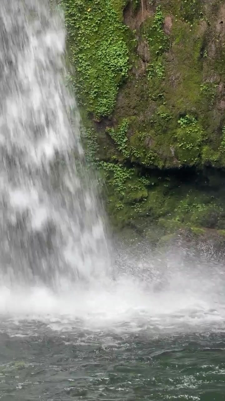 Air Terjun Deras Mengalir di Tebing Batu Berlumut