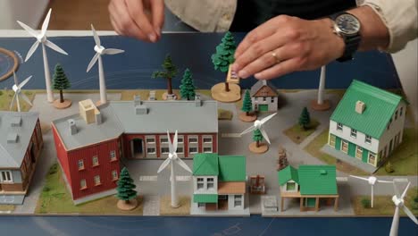 man arranging miniature models for a sustainable city architectural project