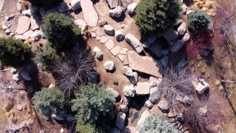 un dron que gira o gira suavemente mirando hacia abajo a los niños y los padres en un parque de escalada en roca para niños en medio de un hermoso día soleado de primavera