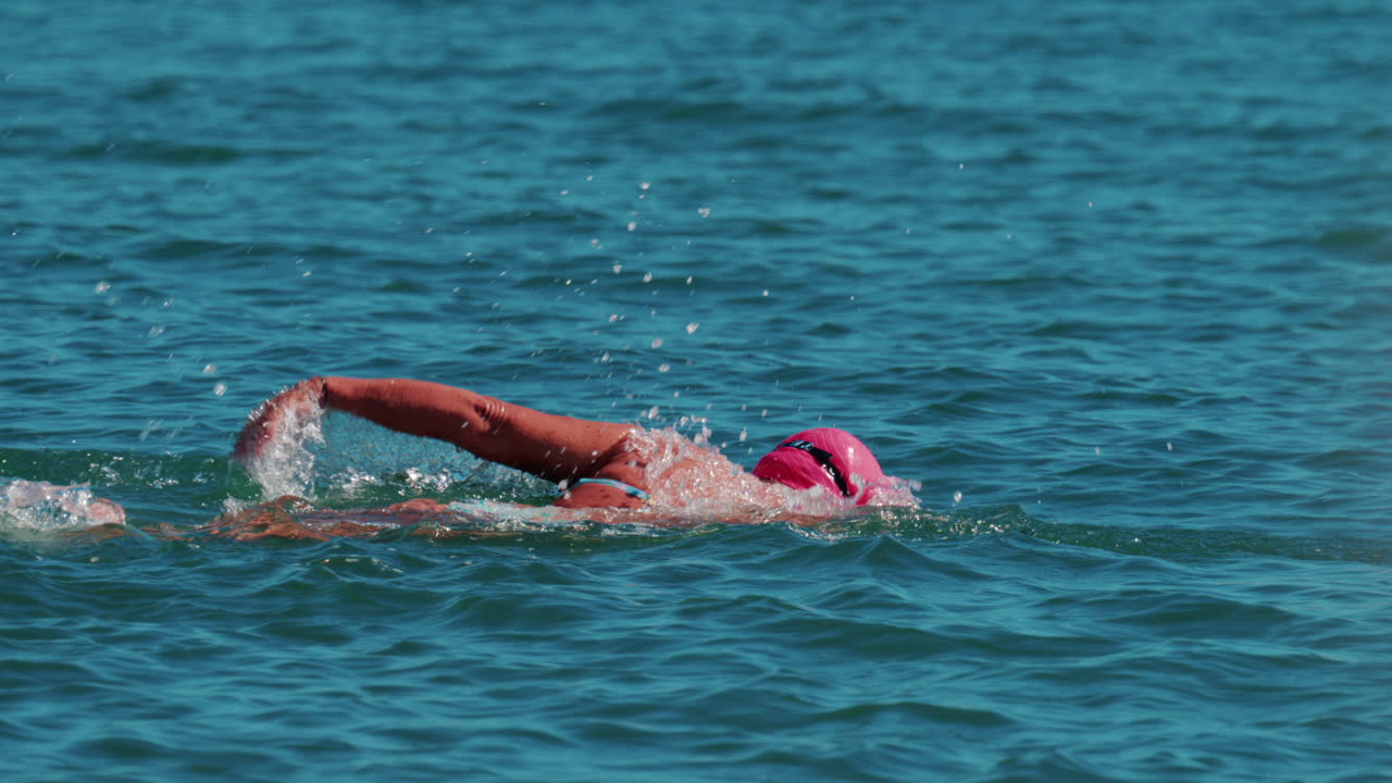 Woman swimming freestyle in the calm turquoise water off the coast of Cannes, France
