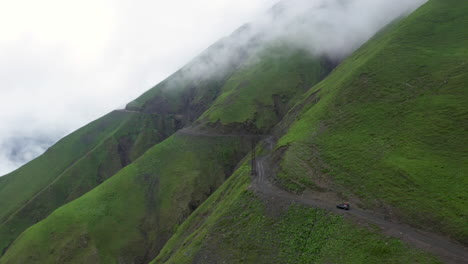 Rotierende-Drohnenaufnahme-Eines-Fahrzeugs,-Das-Auf-Der-Straße-Nach-Tusheti-Fährt,-Einer-Der-Gefährlichsten-Straßen-Der-Welt-In-Georgia