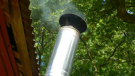 heat fumes coming out of metal pipe on sauna roof, sweden