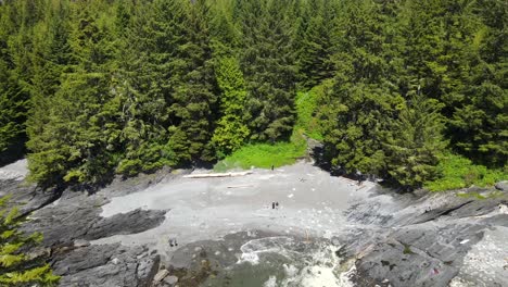 Back-and-upwards-flight-over-small-secluded-bay-on-Vancouver-Islands-rugged-and-wild-west-coast-on-sunnny-day