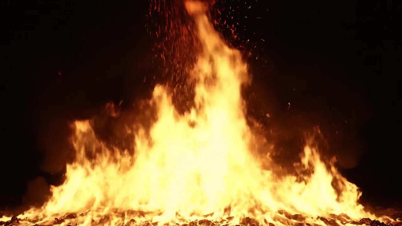 Falò intenso e fiammeggiante con scintille contro un cielo notturno scuro