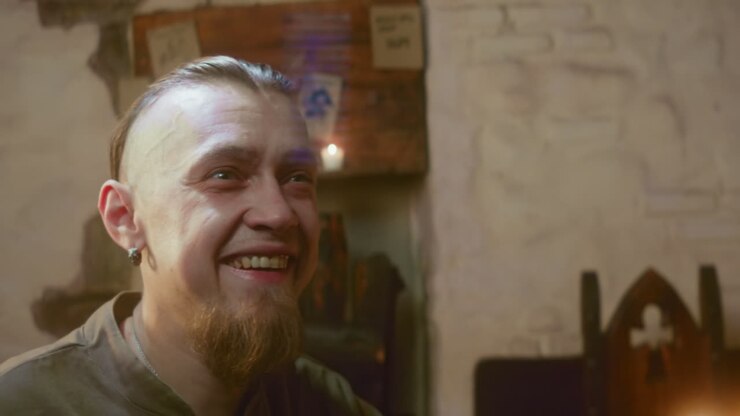 Happy alcoholic flirts and friend holds companion in tavern closeup. Drunk fellow smiles joyfully seeing pretty lady in medieval guesthouse. Fantasy romance