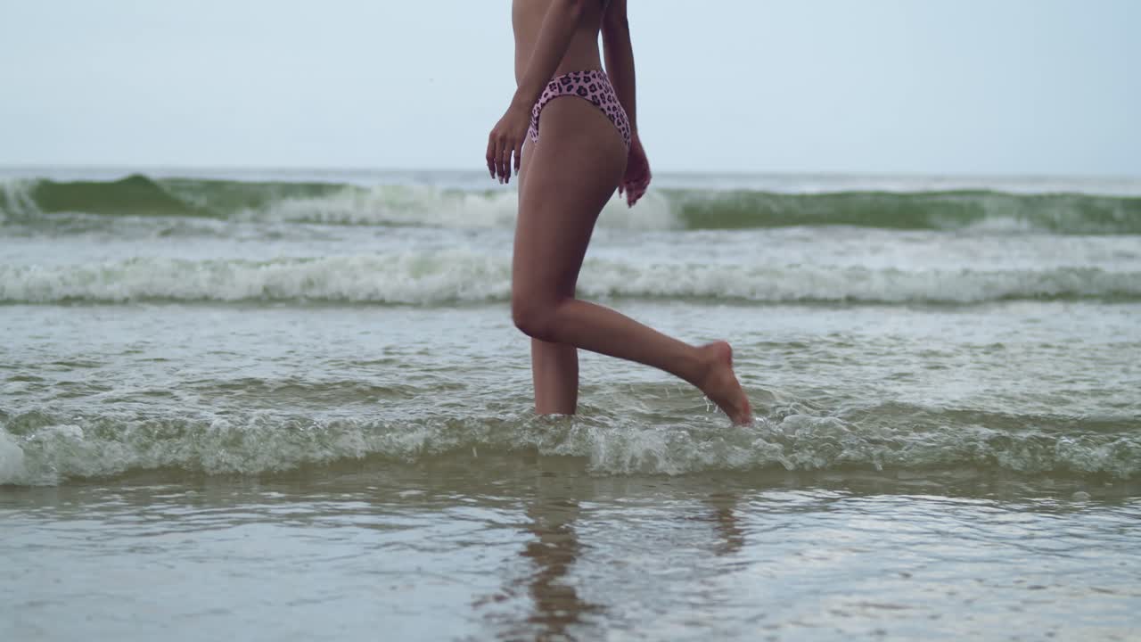 L'incanto della spiaggia caraibica prende vita mentre una donna latina si gode la sua bellezza camminando nelle onde basse dell'oceano.