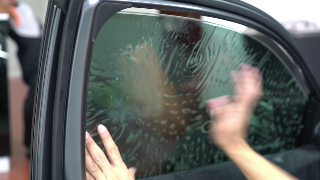 자동차 유리에 틴팅 필름을 설치합니다.