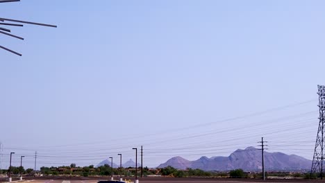 Pan-from-high-tension-powerlines-to-the-huge-metal-horse-sculpture-at-West-World,-Scottsdale,-Arizona