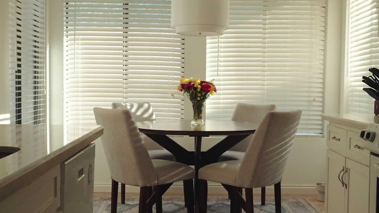 Bright and airy kitchen with a slow-motion slide shot of a table with flowers