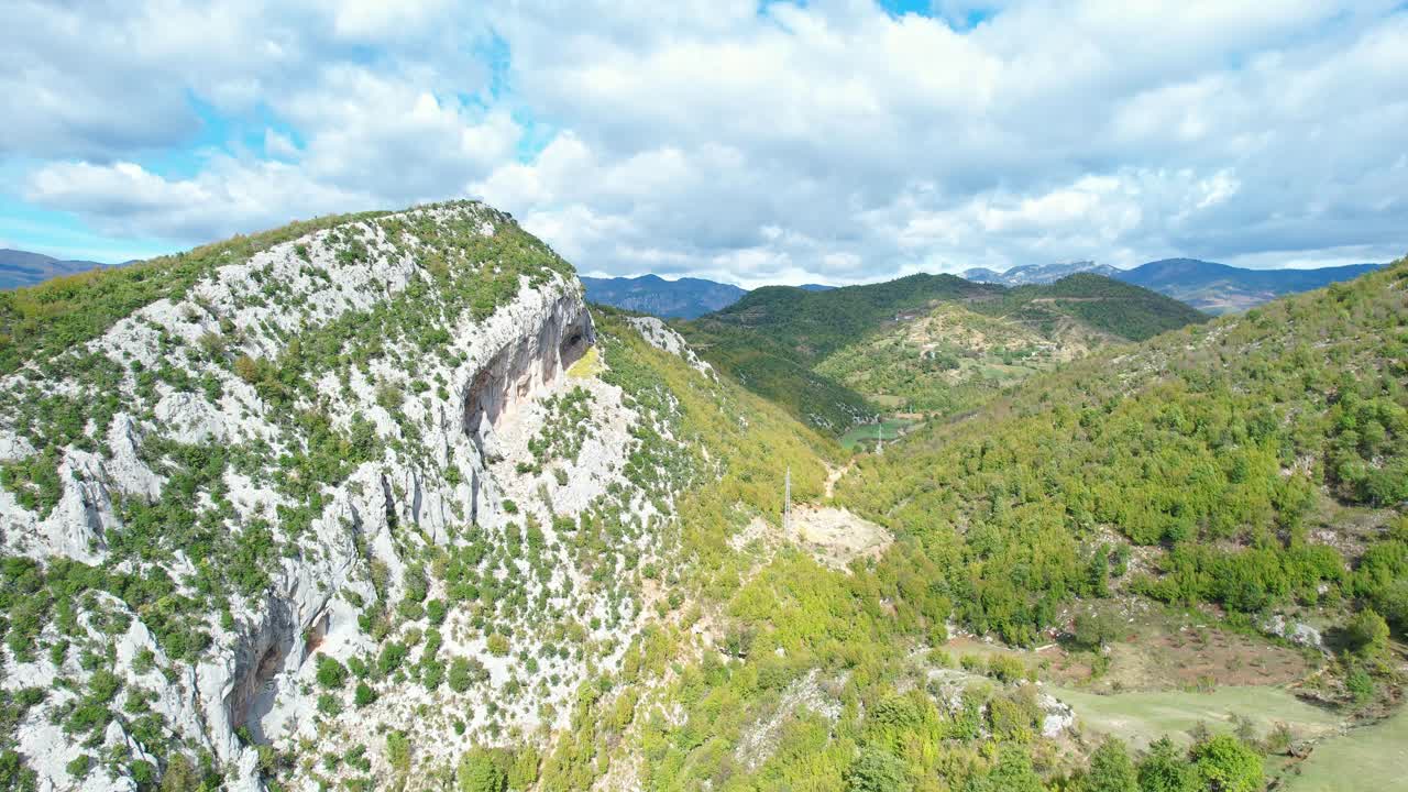 Panoramic shot of the imposing rock cliff in Kabashi, Albania. It captures the vast vegetation and the alpine and mountainous valley landscape