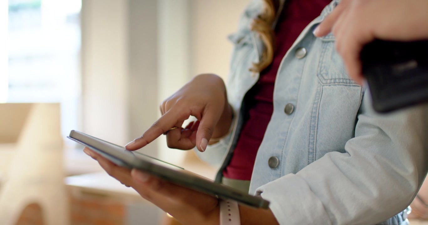Dupla afro-americana perto da janela, mulher segurando tablet interagindo enquanto homem aponta smartphone orientando