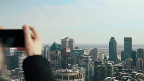 woman takes photo of winter montreal skyline