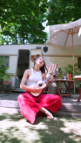 woman playing ukulele on camping trip