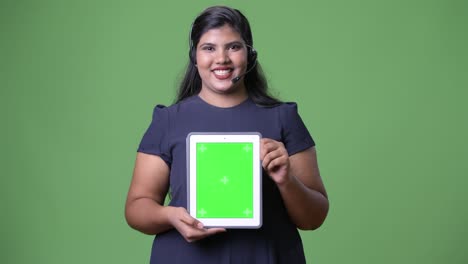 joven sobrepeso hermosa mujer de negocios india contra fondo verde