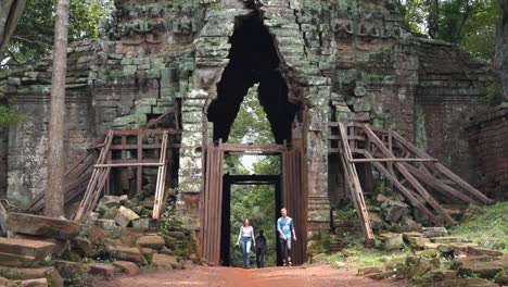 slow motion shot of tourists walking through temple arch at angkor wat