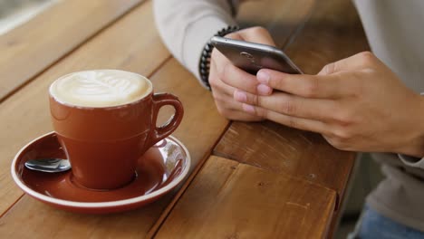 hombre usando teléfono móvil en una cafetería 4k