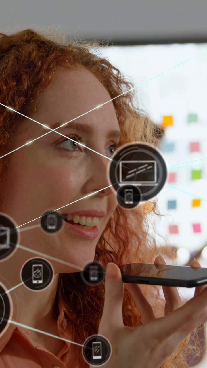 Woman speaking into phone, activating HUD overlay linking devices to laptop for tech demo