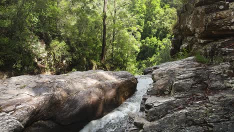 Arroyo-De-Canales-Tallados-En-Agua-A-Través-De-Sólidas-Formaciones-Rocosas-Que-Desaparecen-En-Una-Densa-Selva-Tropical-Debajo