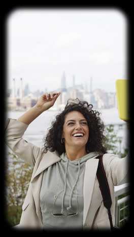 woman with curly hair and pink beanie taking photos