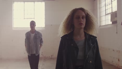 fashionable young man and woman in an abandoned warehouse