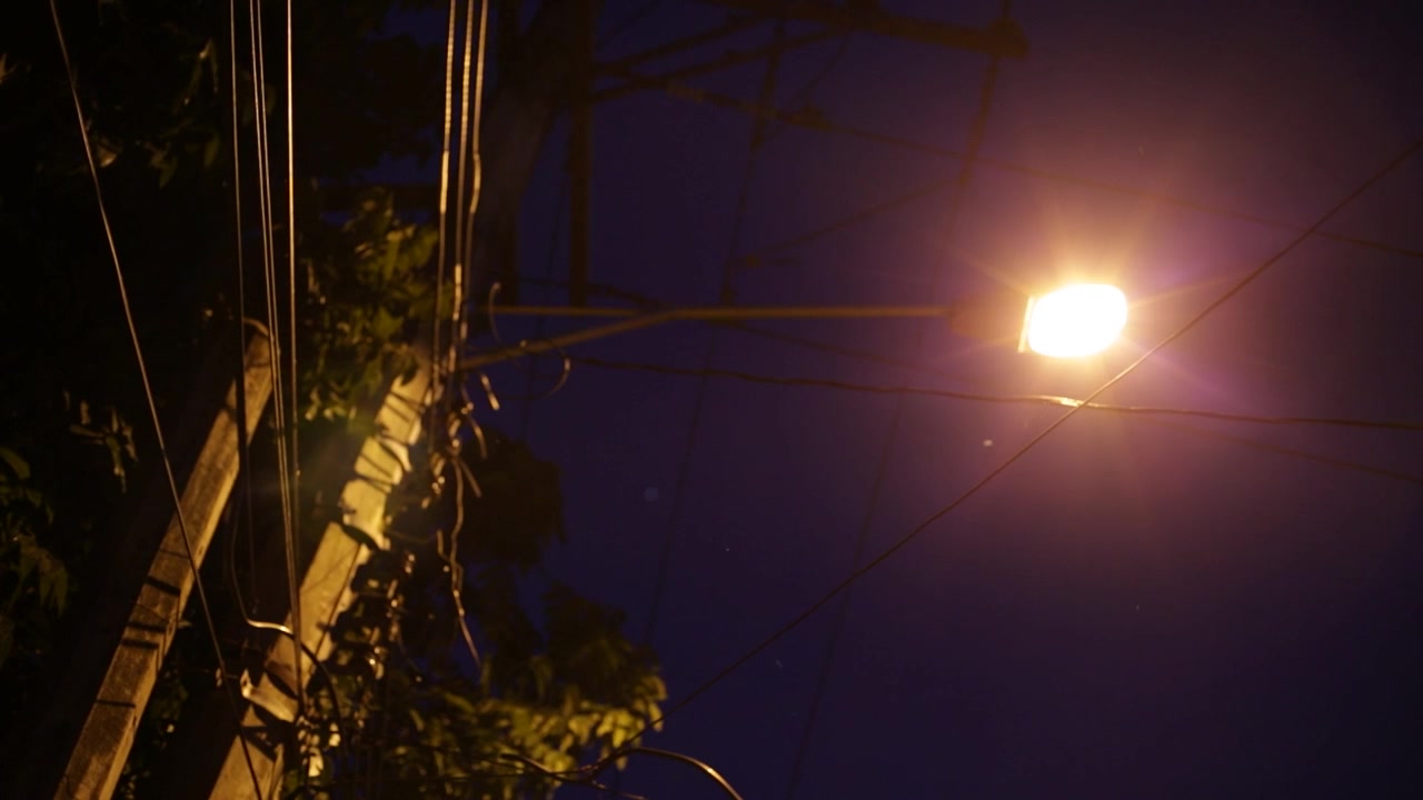 Metraje 4K de farolas brillando por la noche en un entorno urbano, capturando la iluminación atmosférica, el ambiente de la ciudad y la atmósfera nocturna urbana.