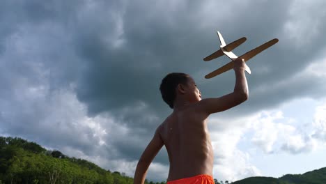 boy playing with a cardboard airplane