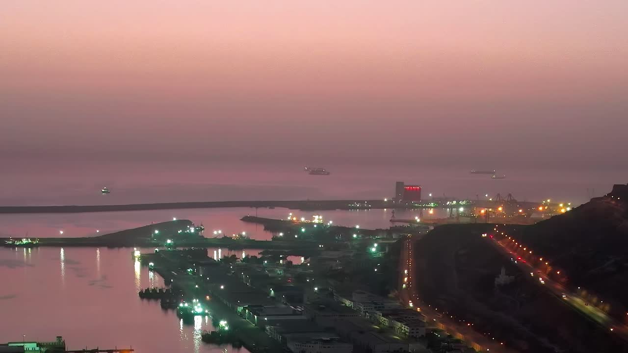 Udsigt over havnen i Marokko ved solnedgang med skibe og lys