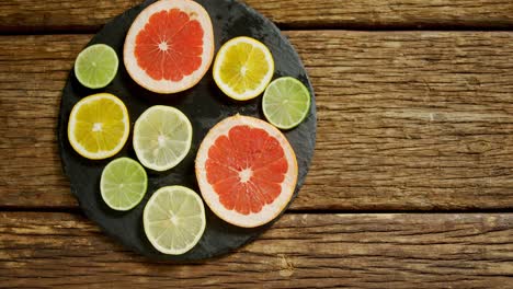 Various-citrus-slices-in-tray-on-wooden-table-4K-4k