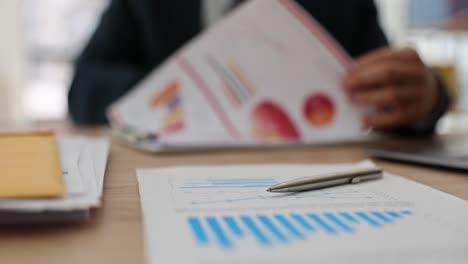 business professional analyzing financial data and charts on a desk