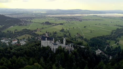 wide aerial around the famous castle neuschwanstein in bavaria germany surrounded by its stunning alps landscape, forrest, marienbrücke and lake alpsee